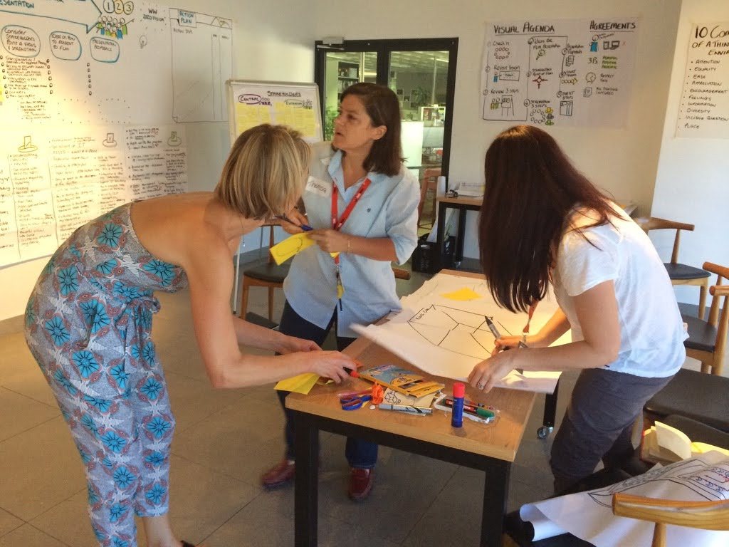 Team members creating ideas together with paper and pens