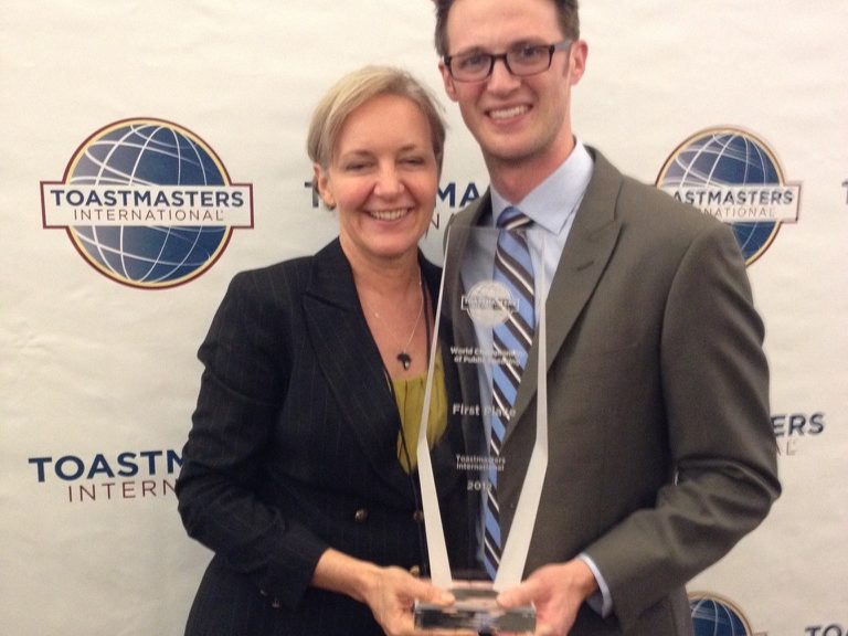 Kay beside a trophy holder at the Toastmasters World Championships